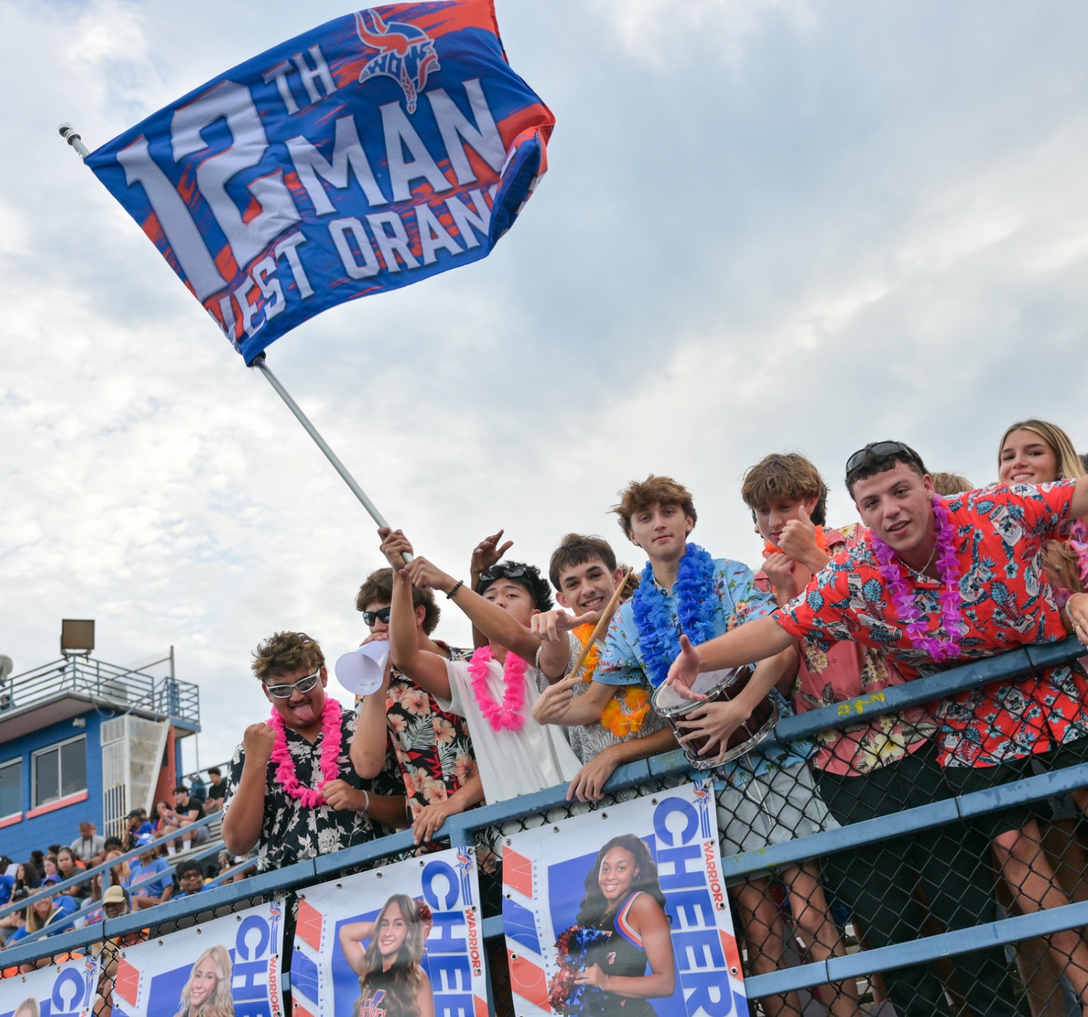 West Orange students cheering with a Warriors flag in the stands.